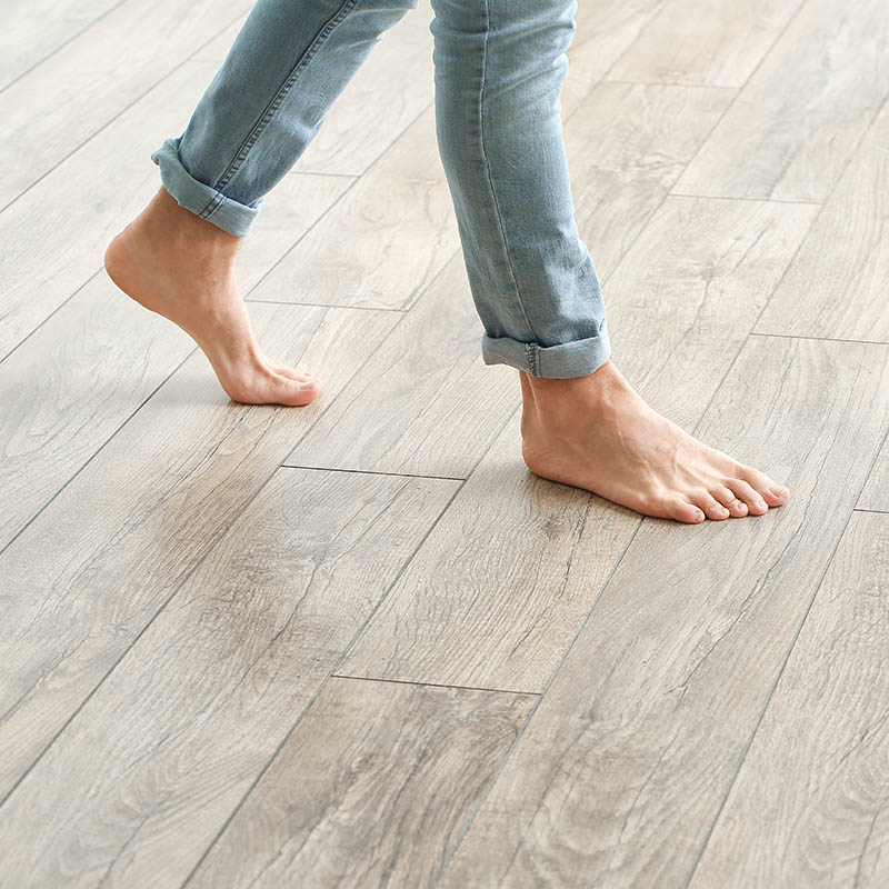 Man walking on new laminate flooring at home