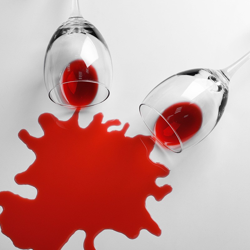 Red wine spilled from glass on white background