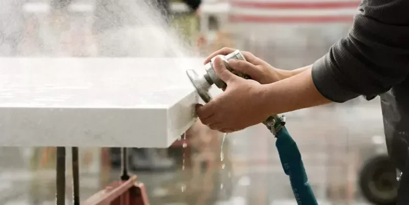 Installation professional sanding a quartz countertop edge