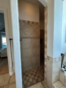 Master bathroom walk-in shower with neutral stone tile