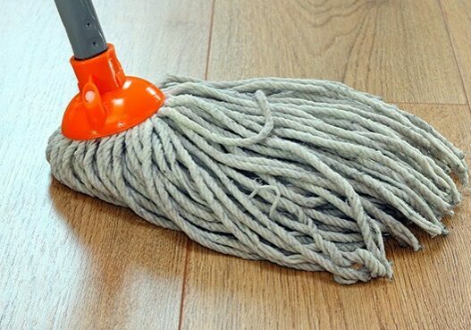 detail of a mop cleaning wooden floor